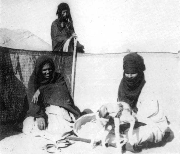 Ζευγάρι νεαρών Tuareg στην είσοδο του asaber. Πίσω τους ένας υπηρέτης Σουδανέζικης καταγωγής.