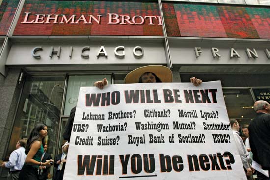 Διαδηλωτής με πλακάτ έξω από το κτίριο της Lehman Brothers. Είναι η 15η Σεπτεμβρίου 2008, την ημέρα που η επενδυτική τράπεζα ζητά να μπει σε διαδικασία πτώχευσης, ύστερα από 158 χρόνια λειτουργίας.