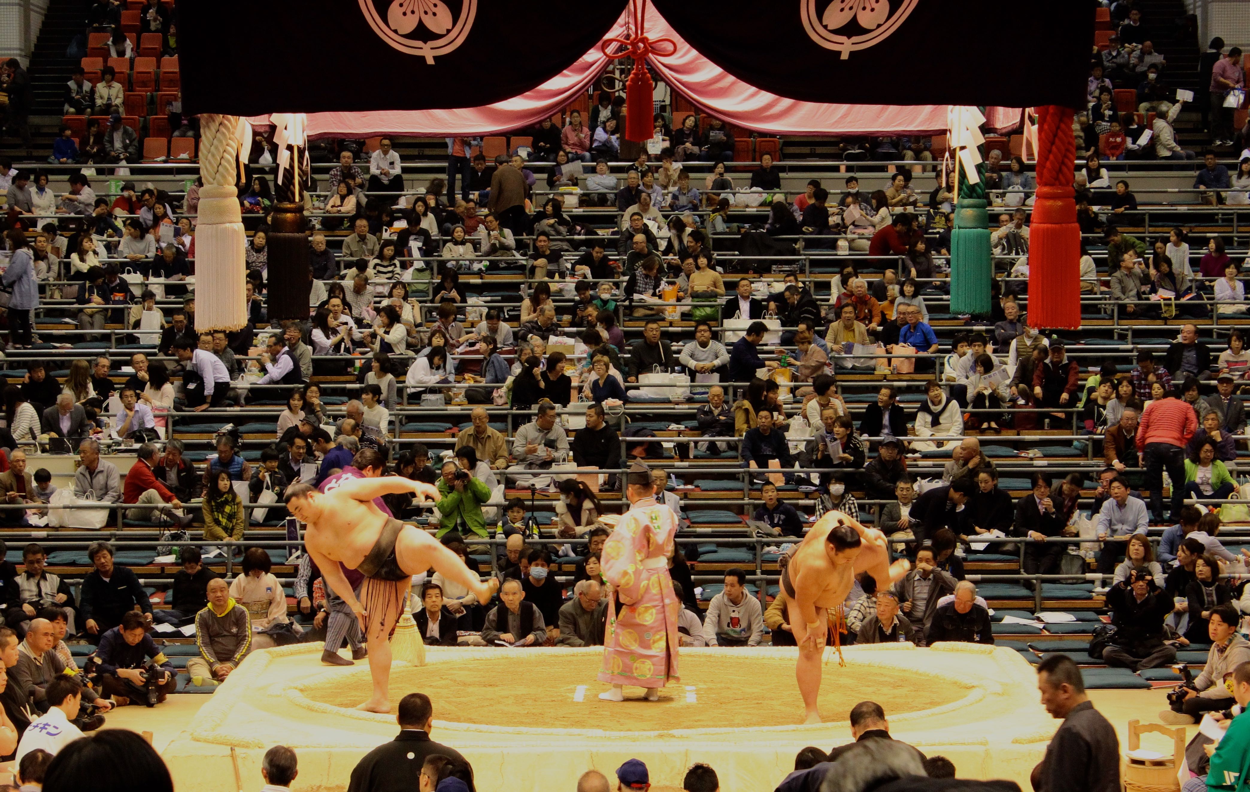 Οι rikishi σε τελετουργικό με τον διαιτητή στο κέντρο.